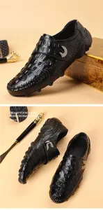Gros plan de mocassins en cuir noir avec motif crocodile et boucle métallique pour homme.