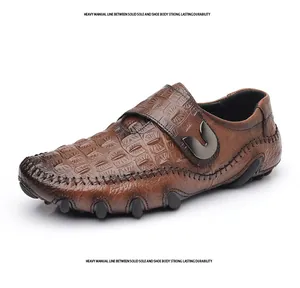 Détail d'un mocassin en cuir marron à motif crocodile avec des surpiqûres manuelles