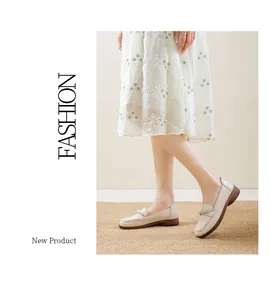 Detail showing cream slip-on loafers with a soft sole and low heel on a mat.