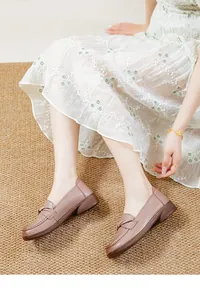 Comfortable soft brown leather loafers for women with a decorative bow on a textured rug