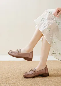 Close-up of comfortable brown leather loafers for women with decorative knot on upper.