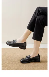 Detailed side view of comfortable black slip-on loafers with textured soles on a rug