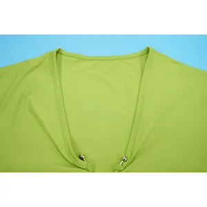 Close-up detail of sexy deep V neckline with silver metal bead accents on lime green dress