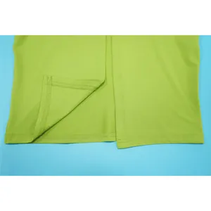 Detail shot of lime green dress hem showing high-quality stitching and fabric texture.