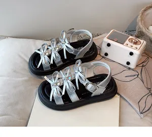 Detailed view of silver girls sandals with triple bow accents and thick soles