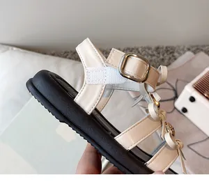 Close-up of girl's thick sole summer sandals with cream leather and bow details