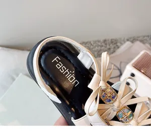 Detailed macro view of the white bow and colorful gemstone on this girl's sandal.