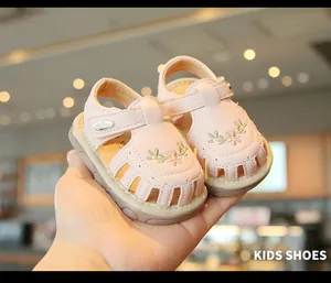 Nahaufnahme von rosa Sandalen für Kleinkinder mit Blumenstickerei und atmungsaktivem Design