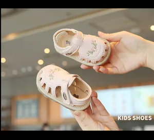 Nahaufnahme von rosa Baby-Sandalen für Mädchen mit Blumenstickerei und Design
