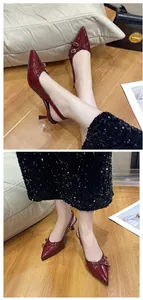 Dettaglio delle scarpe rosse verniciate a punta con cinturini e fibbie eleganti.