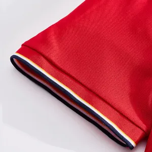 Close-up detail of red mesh polo shirt sleeve with tricolor striped ribbed cuff