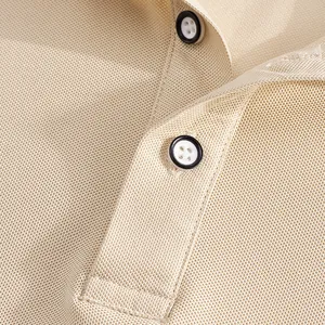 Close-up detail of beige mesh pique fabric and buttons on men's quick-dry polo shirt