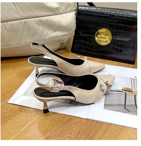 Dettaglio di scarpe slingback beige a punta con eleganti fibbie decorative