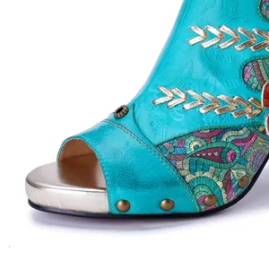 Close-up of handmade turquoise leather sandal with intricate embroidery and studs