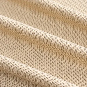 Close-up macro view of breathable beige mesh fabric texture for men's quick-dry Polo shirt.