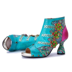 Detailed view of genuine leather peep-toe ankle boots with handmade 3D floral accents.