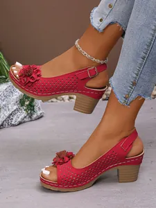 Detail showing red floral high heel sandals with laser-cut hollow pattern and buckle strap design