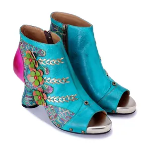 Detailed view of handmade leather boots with 3D flower decor and patchwork design.