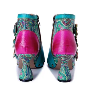 Rear view of vibrant handmade leather boots featuring floral patterns and a unique glass heel