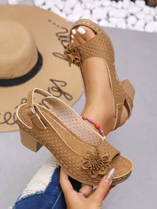 Detail view of khaki women's floral sandals with laser-cut patterns and chunky heels