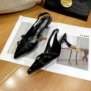 Eleganti scarpe nere a punta slingback con fibbie metalliche su una rivista di moda