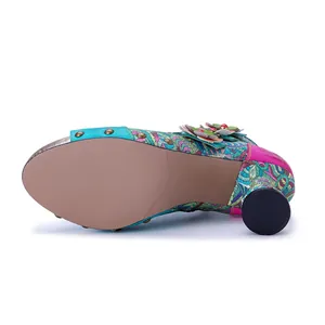 Detail view of colorful floral high heel sandal showing patterned sole and 3D flower accents.