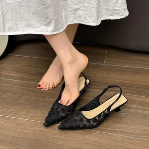 Detailed close-up showing black floral lace mesh on pointed-toe slingback kitten heels