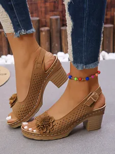 Close-up of brown platform sandals featuring 3D flower detail and laser-cut design