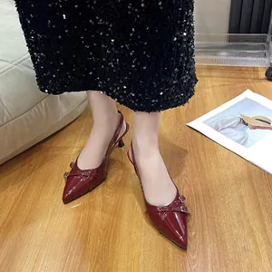 Eleganti décolleté slingback bordeaux con dettaglio fibbia su pavimento in legno