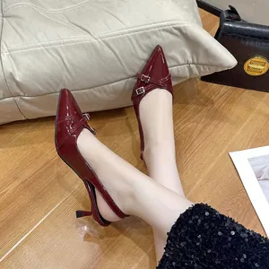 Dettaglio di scarpe bordeaux lucide con punta affusolata e cinturini con fibbia