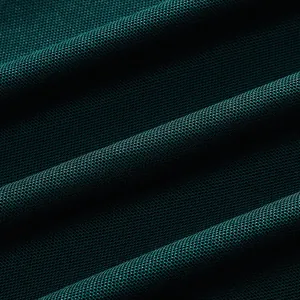 Macro detail of breathable dark green mesh fabric for men's quick-dry sports polo shirt