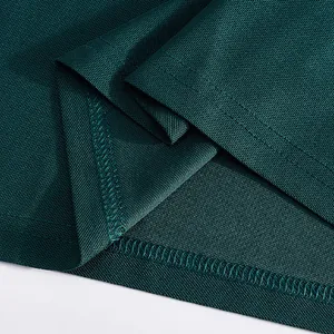 Macro view of dark green mesh fabric texture and durable stitching detail on a polo shirt