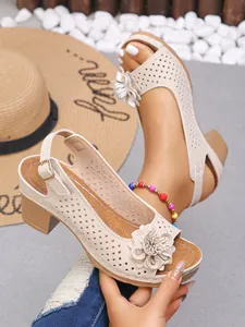 Detailed macro view of beige women's high-heel sandals with 3D flower and laser-cut upper.