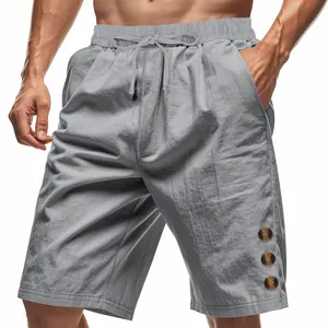 Detail shot of men's grey linen shorts with decorative buttons and drawstring waist.