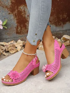 Detail of pink floral high heel sandals with laser-cut design and ankle buckle strap.