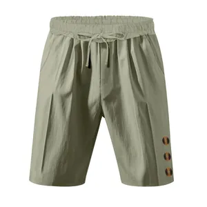 Close-up of olive green drawstring shorts featuring unique decorative side buttons