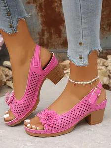 Close-up of pink floral high heel sandals with hollow-out design and buckle strap