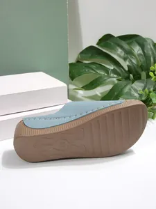 Bottom view of blue wedge sandal showing brown non-slip sole and stitching details