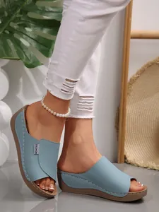 Detailed view of light blue platform wedge sandals featuring fashion label and stitching