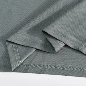 Macro view of breathable mesh fabric and durable double-needle stitching on grey Polo shirt.