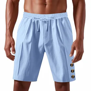 Detail view of men's loose light blue linen shorts with drawstring waist and buttons.
