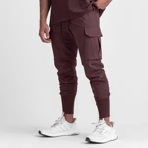 Vue détaillée du jogging cargo bordeaux pour hommes avec cordon de serrage et poignets.