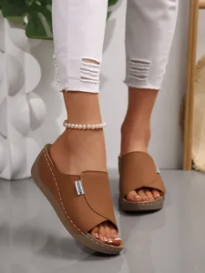 Detailed view of stylish brown platform wedge sandals with white stitching and peep-toe design