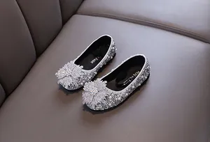Detailed view of silver rhinestone girls' princess shoes with pearl flower accents
