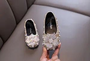 Close-up detail of shimmering rhinestone flower decoration on elegant girls princess dress shoes