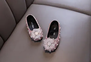 Close-up of sparkly pink rhinestone princess shoes with decorative flower