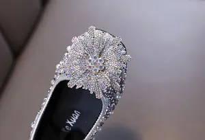 Close-up detail of glittering rhinestone flower on silver girl's princess shoes