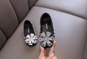 Nahaufnahme schwarzer Prinzessinnenschuhe für Mädchen mit glitzerndem Strassblumendetail
