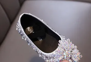 Close-up of girls' princess shoes with sparkling rhinestones and elegant pearls.