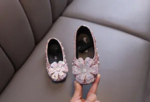 Nahaufnahme von rosa Prinzessinnenschuhen für Mädchen mit glitzernder Straßblume